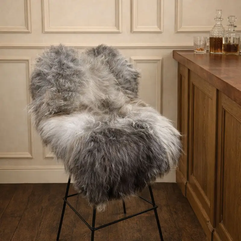 British rare breed sheepskin rug with flowing long wool texture layered over a metal bar stool