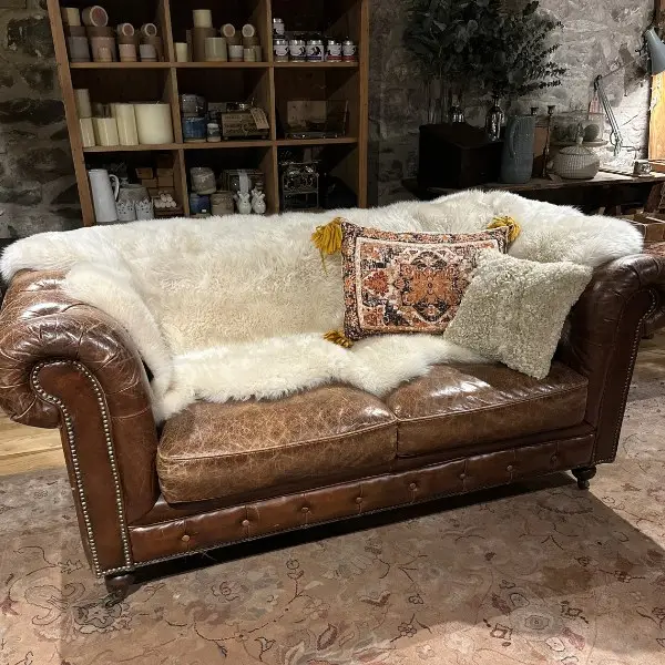 Sheepskin Quad rug in Seashell on a leather sofa