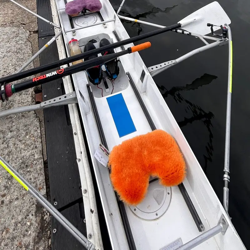 Sheepskin rowing seat pad in a touring rowing boat, made from soft short-wool sheepskin offcuts by Baa Stool in North Wales.
