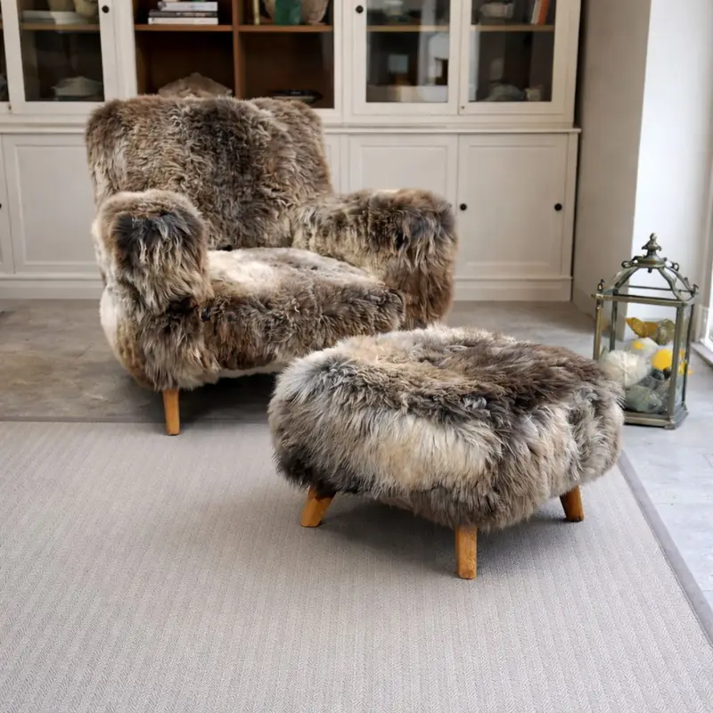 The Wooligan rare breed sheepskin armchair in a light and neutral living room with matching footstool.
