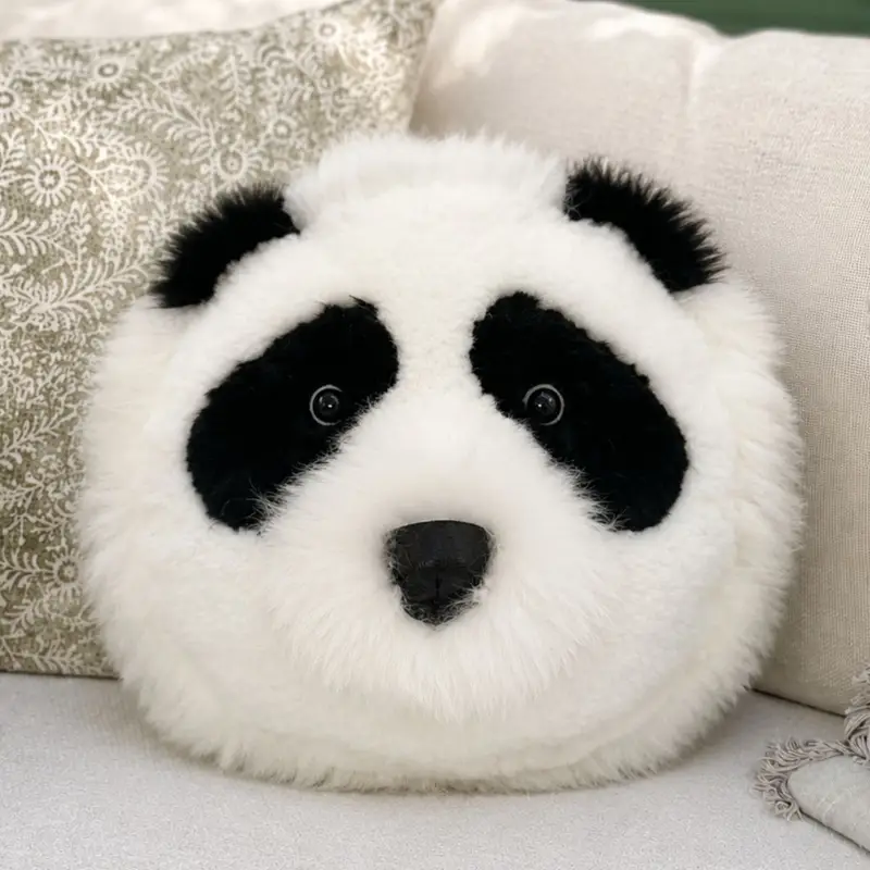 Woolly Wild panda sheepskin cushion on a cream sofa.