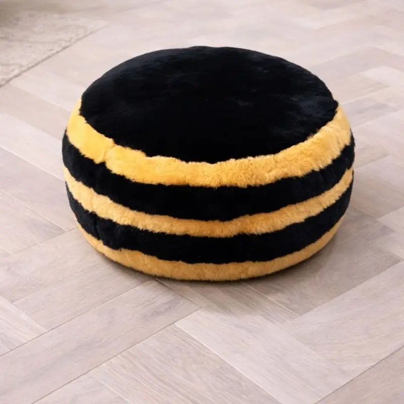 Bumble Bee design sheepskin pouffe in a neutral room close up