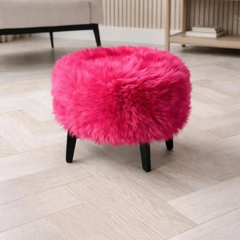 Bright pink footstool in a neutral room setting.