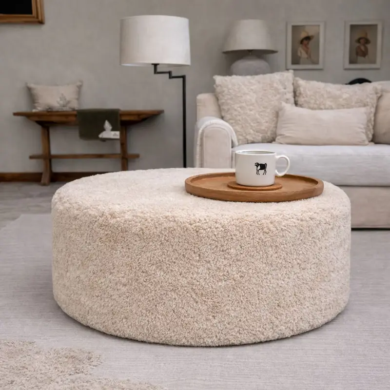 Extra Large Shearling sheepskin Pouffe in Eggshell Extra large size shearling sheepskin pouffe in a neutral room next to a sofa in eggshell colour.