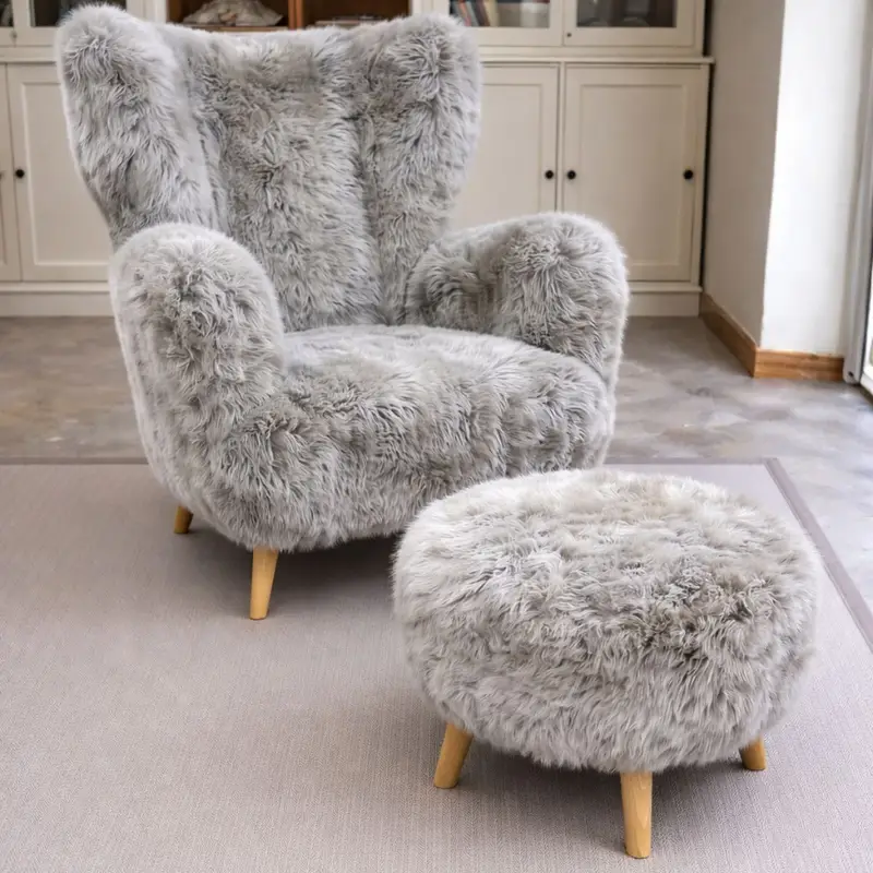 Sheepskin armchair with matching round footstool styled in a warm contemporary interior