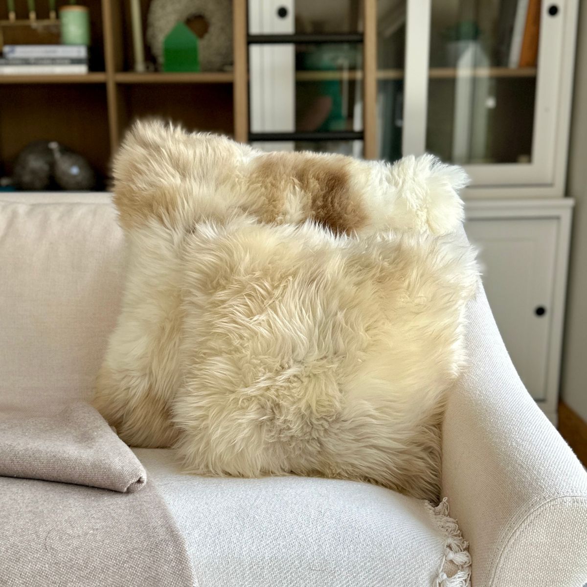 British Rare Breed Sheepskin cushions on a cream sofa.