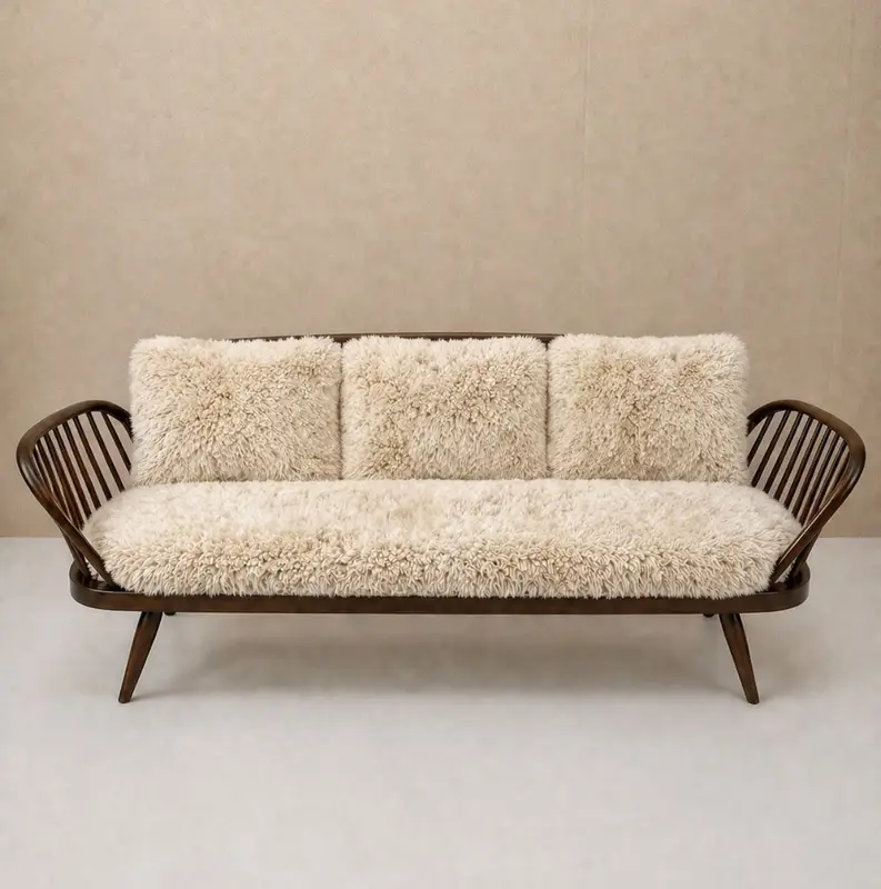 Ercol Studio Couch showing dark coloured ash frame and eggshell coloured sheepskin cushions.