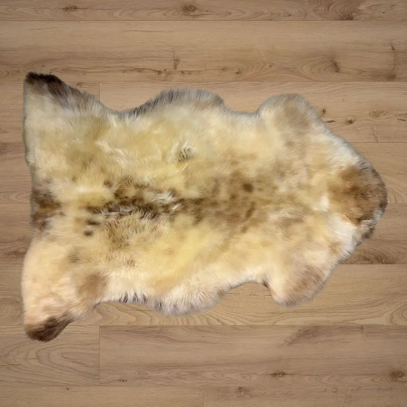 A silky textured rug in cream with caramel freckles.