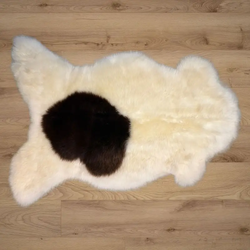 An ivory rug with a lovely chocolate splotch and a very silky texture.