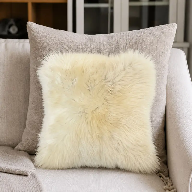 Sheepskin cushion with natural markings on a cream sofa.