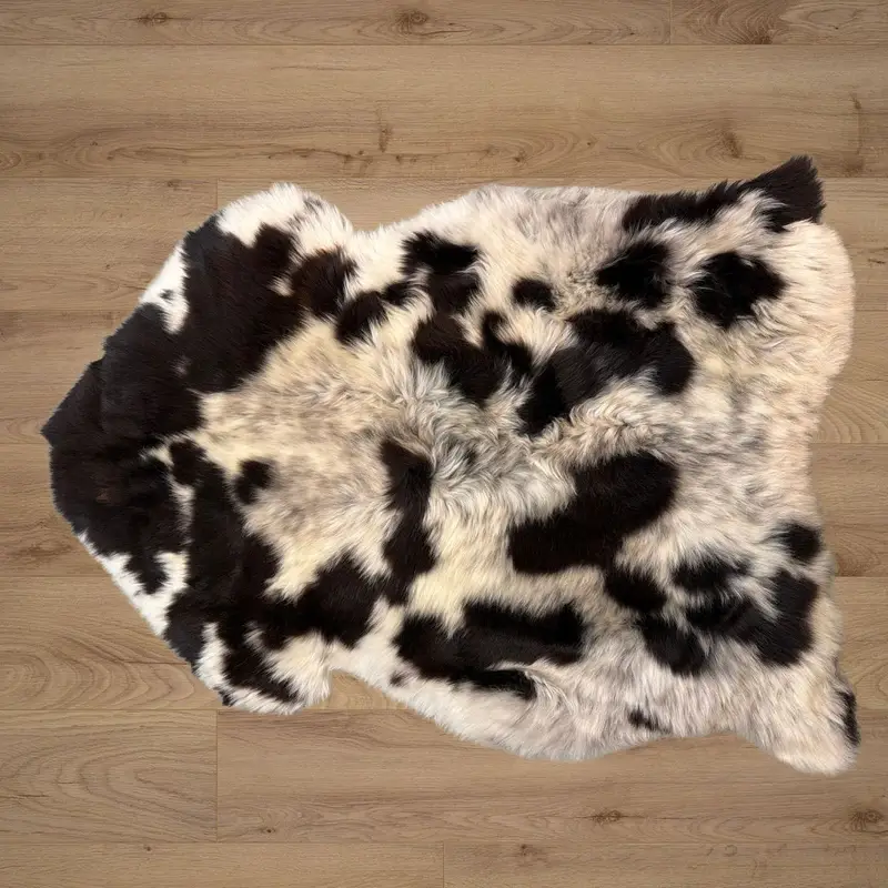 An ivory rug with grey freckles and deep mocha splotches, with a very soft and silky pile.