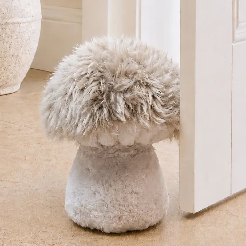 Lifestyle image of a Handmade field mushroom sheepskin doorstop with a fluffy mushroom coloured cap, velvety stalk and shorn sheepskin gills.