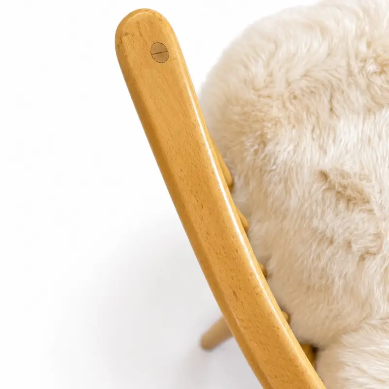 Close up of arm of Ercol Model 766 lounge chair upholstered in pale Seashell sheepskin