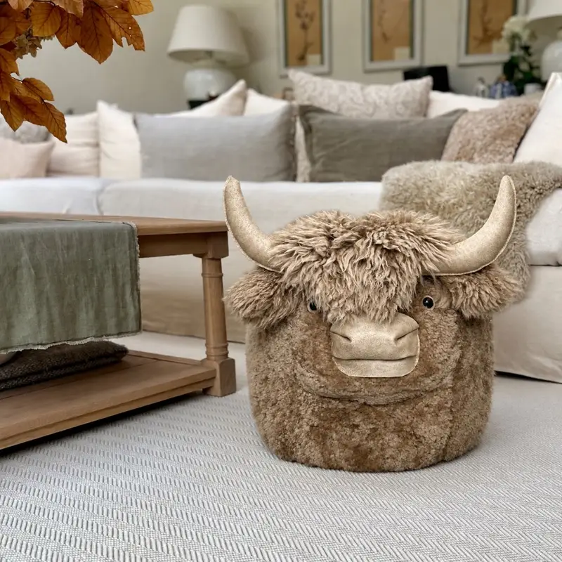 Biscuit large Jersey cow sheepskin pouffe styled in a living room